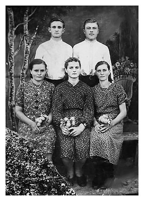 Emma Geier wurde im September 1941 von der Wolga nach Kasachstan deportiert. 1942 wurde sie in die Trudarmee einberufen, wobei es zu einem Autounfall kam, den Emma überlebte. So entging sie der Trudarmee, wurde allerdings als Lehrerin für Biologie, Chemie, Erdkunde und Deutsch in der Sondersiedlung eingesetzt. Das Bild zeigt sie mit weiteren deutschstämmigen Jugendlichen im Deportationsort Mynbulak in Ostkasachstan.  